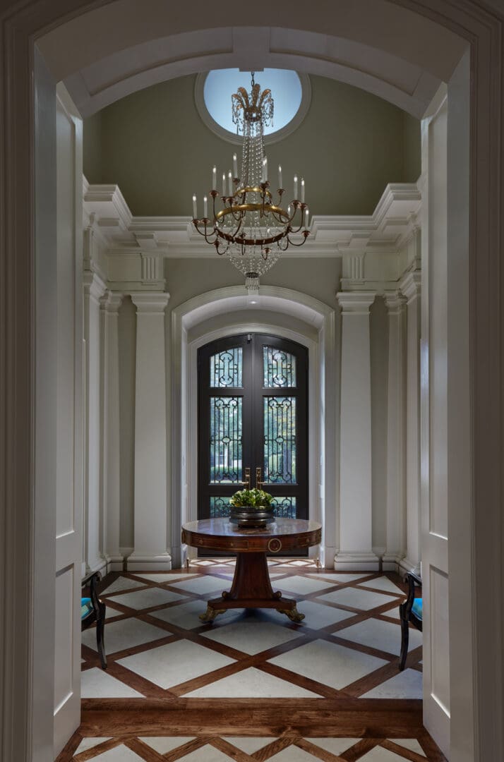 A foyer with a table and chandelier in it